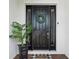 Welcoming black front door adorned with a green wreath, a potted plant, and a checkered welcome mat at 6229 Sea Air Dr, Apollo Beach, FL 33572