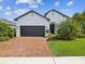 Inviting home with a brick driveway, well-manicured lawn, and an attached two-car garage at 6229 Sea Air Dr, Apollo Beach, FL 33572