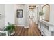 Warm hallway featuring wood flooring, an ornate mirror, and a view through to a well-lit living space at 6229 Sea Air Dr, Apollo Beach, FL 33572