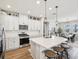 Well-lit kitchen with a central island, bar stool seating, stainless steel appliances, and white cabinetry at 6229 Sea Air Dr, Apollo Beach, FL 33572