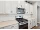 Modern kitchen with white cabinetry, stainless steel appliances, and stylish black hardware, offering functionality at 6229 Sea Air Dr, Apollo Beach, FL 33572
