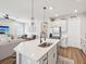 Open-concept kitchen featuring an island with stainless steel sink, white cabinets, and pendant lighting at 6229 Sea Air Dr, Apollo Beach, FL 33572