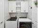 Modern laundry room featuring front-loading washer and dryer and upper cabinets at 6229 Sea Air Dr, Apollo Beach, FL 33572