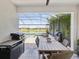 Covered lanai with dining table overlooking the pool and lake, perfect for outdoor meals and gatherings at 6229 Sea Air Dr, Apollo Beach, FL 33572