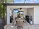 Covered outdoor dining with tv, grill, fan, and travertine tile at 6229 Sea Air Dr, Apollo Beach, FL 33572