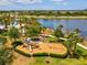 Community playground with slides and swings surrounded by lush landscaping and a serene lakeside view at 6229 Sea Air Dr, Apollo Beach, FL 33572