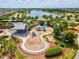 Aerial view of community playground with multiple play structures, seating, and walking paths by lake at 6229 Sea Air Dr, Apollo Beach, FL 33572