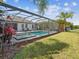Screened-in pool with palm trees, grass, and landscaping at 6229 Sea Air Dr, Apollo Beach, FL 33572