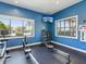 Light and airy workout room featuring modern machines, a TV, and AED, with views of the pool at 6229 Sea Air Dr, Apollo Beach, FL 33572