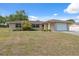Charming single-story home featuring an attached garage, manicured lawn, and mature landscaping under clear blue skies at 6340 Hillview Rd, Spring Hill, FL 34606