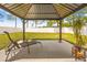 Relaxing backyard gazebo with lounge chair, potted plants, and a peaceful view of the fenced yard at 635 Painted Leaf Dr, Brooksville, FL 34604