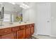 Bright bathroom with a double sink vanity, framed mirror, and beige countertops at 635 Painted Leaf Dr, Brooksville, FL 34604
