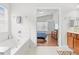 Bright primary bathroom featuring a soaking tub and a doorway view of the bedroom at 635 Painted Leaf Dr, Brooksville, FL 34604