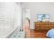 Cozy bedroom featuring wood floors, a window with blinds, and a wooden dresser with a TV at 635 Painted Leaf Dr, Brooksville, FL 34604