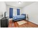 A clean bedroom with a blue bed set, wood floors, and natural light at 635 Painted Leaf Dr, Brooksville, FL 34604