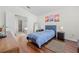 Cozy bedroom with wood floors, a blue bed, and access to a well-lit bathroom with a tub at 635 Painted Leaf Dr, Brooksville, FL 34604