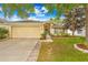 Charming single-story home features a well-manicured lawn, beige exterior, and attached two-car garage at 635 Painted Leaf Dr, Brooksville, FL 34604
