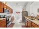 Bright kitchen with stainless steel appliances, tiled flooring, and ample wooden cabinet space, adjacent to eat in kitchen space at 635 Painted Leaf Dr, Brooksville, FL 34604