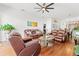 Spacious living room with leather sofas, a ceiling fan, and a seamless transition to the dining area at 635 Painted Leaf Dr, Brooksville, FL 34604