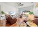 Cozy living room with leather furniture, ceiling fan, and sliding glass doors leading to the backyard at 635 Painted Leaf Dr, Brooksville, FL 34604
