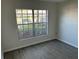 This bedroom offers new floors, a large window with natural light, and neutral walls at 6440 Spring Flower Dr # 14, New Port Richey, FL 34653