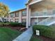 Inviting condo exterior features manicured landscaping, and a covered walkway leading to the entrance at 6440 Spring Flower Dr # 14, New Port Richey, FL 34653