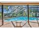 Inviting screened-in pool with brick pavers and an attached spa surrounded by lush landscaping at 7129 Myrtlewood Ln, Spring Hill, FL 34606