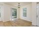 Bright dining area features wood floors, backyard access, and modern light fixture at 7500 Red Mill Cir, New Port Richey, FL 34653