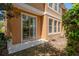 Exterior corner view of the home featuring a sliding glass door and multiple windows at 7500 Red Mill Cir, New Port Richey, FL 34653