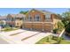 A three-story stucco home featuring multiple car garages, second story balconies, and verdant lawns at 7500 Red Mill Cir, New Port Richey, FL 34653