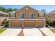 Two-story townhome featuring three garage doors and charming Juliette balconies on the second level at 7500 Red Mill Cir, New Port Richey, FL 34653