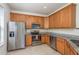 Well-lit kitchen features stainless steel appliances, granite countertops, and wooden cabinetry at 7500 Red Mill Cir, New Port Richey, FL 34653