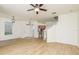 Open-concept living room with wood floors, ceiling fan and staircase access at 7500 Red Mill Cir, New Port Richey, FL 34653