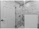 Modern bathroom features marble tile shower, glass door, and white hexagon tile flooring at 8505 Lincolnshire Dr, Hudson, FL 34667