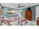 Bedroom featuring aqua-colored walls and a natural wood accent wall with a TV at 8505 Lincolnshire Dr, Hudson, FL 34667