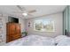 Well-lit bedroom with ceiling fan, wooden dresser with TV, and patterned wallpaper at 8505 Lincolnshire Dr, Hudson, FL 34667