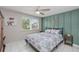Bright bedroom with ceiling fan, decorative wall art, and natural light from a large window at 8505 Lincolnshire Dr, Hudson, FL 34667