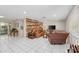Spacious living room with tile floors, wood accent wall, and large windows with backyard views at 8505 Lincolnshire Dr, Hudson, FL 34667