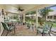 Screened-in patio with patterned tile flooring, ceiling fan, and outdoor seating at 8505 Lincolnshire Dr, Hudson, FL 34667