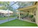 Enclosed patio with ceiling fan, decorative plants, comfortable seating and artificial turf extending to the screen at 8505 Lincolnshire Dr, Hudson, FL 34667