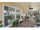 Covered patio with patterned tile flooring, ceiling fan, seating, and sliding glass doors at 8505 Lincolnshire Dr, Hudson, FL 34667