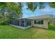 A well-maintained home with a screened lanai and a view of the lush, green backyard at 8505 Lincolnshire Dr, Hudson, FL 34667