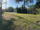 Large front yard with a charming single-story home and lush greenery at 8711 Cutlass Dr, Hudson, FL 34667