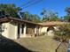 Charming single-story home with stucco siding, stone accents, and a metal gate leading to the front entrance at 8711 Cutlass Dr, Hudson, FL 34667