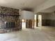 View of the living room with stone fireplace and original tile flooring, ready for renovation at 8711 Cutlass Dr, Hudson, FL 34667