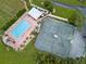Aerial view of pool and tennis courts surrounded by lush landscaping and tropical trees at 9147 Rhett Ln, Weeki Wachee, FL 34613