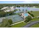 Aerial view of a community pool, tennis courts, landscaping, and mature trees in a neighborhood at 9147 Rhett Ln, Weeki Wachee, FL 34613