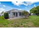 Picturesque backyard showcasing a screened patio and lush green lawn, perfect for relaxation and recreation at 9147 Rhett Ln, Weeki Wachee, FL 34613
