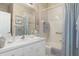 Bright bathroom featuring vanity sink, decorative wallpaper and neutral tiled bathtub with shower at 9147 Rhett Ln, Weeki Wachee, FL 34613