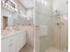 Bathroom featuring a double vanity, large mirrors, and a frameless glass shower with tile surround at 9147 Rhett Ln, Weeki Wachee, FL 34613